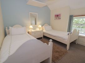 A bedroom with two single beds and a nightstand at Ysgoldy in Dolwyddelan