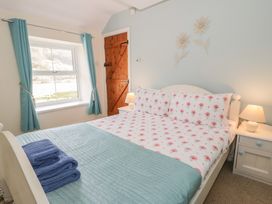 A bedroom with a bed and bedside table at Ysgoldy in Dolwyddelan