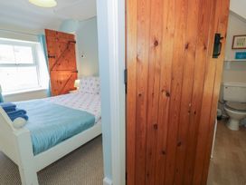 A bedroom with a bed and a door to the bathroom at Ysgoldy in Dolwyddelan