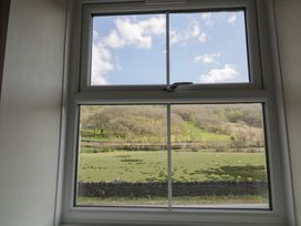 A window view of a field with sheep and mountains at Ysgoldy in Dolwyddelan