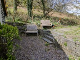 A garden with wooden benches and stone steps at Ysgoldy in Dolwyddelan