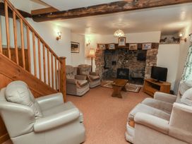 A living room with a fireplace and seating at Denhill Cottage