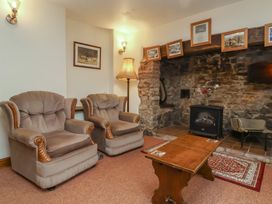 A living room with two armchairs and a table at Denhill Cottage