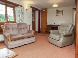 A living room with a sofa and armchair at Denhill Cottage