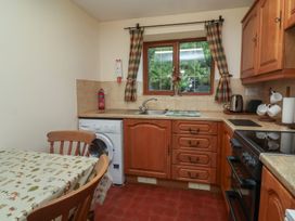 A kitchen with a table and washing machine at Denhill Cottage in 
