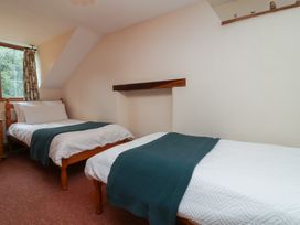 A bedroom with two beds and a window at Denhill Cottage 