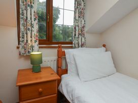 A bedroom with a bed and a nightstand at Denhill Cottage