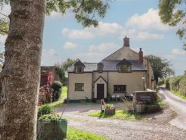 A cottage with a garden and pathway at Denhill Cottage in Chipstable near Wiveliscombe