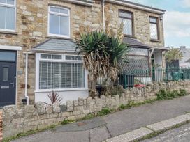The exterior of a house with plants and a stone wall at Sea Boots in Newquay