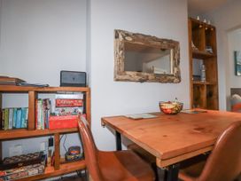 A dining room with a table and shelves at Sea Boots in Newquay