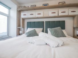 A bedroom with a bed and shelving at Sea Boots in Newquay