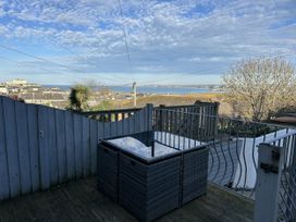 A deck with a table and view of the sea at Sea Boots in Newquay