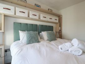 A bedroom with a bed and shelves at Sea Boots in Newquay