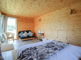 A bedroom with a bed and sofa at Bluebell Lodge in Hastings