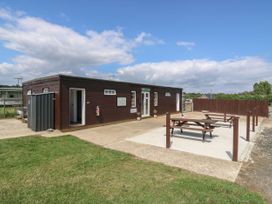 An outdoor area with a building and picnic table at Bluebell Lodge in Hastings