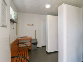 A hallway with a bench and trash can at Bluebell Lodge in Hastings
