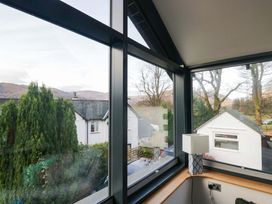 A room with a window view of houses and trees at Two Hollens in Ambleside