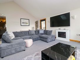 A living room with a grey sofa and television at Two Hollens in Ambleside