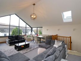 A living room with couches and a dining area at Two Hollens in Ambleside