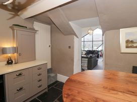 A living room with a cabinet and table at Two Hollens in Ambleside