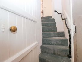 A staircase with carpet and a door at Two Hollens in Ambleside