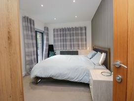 A bedroom with a bed and curtains at Two Hollens in Ambleside