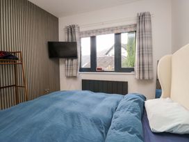 A bedroom with a bed and a television at Two Hollens in Ambleside