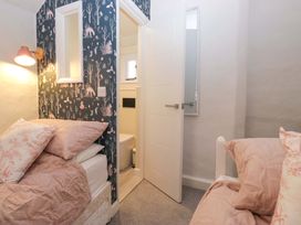 A bedroom with beds and a door leading to a bathroom at Two Hollens in Ambleside
