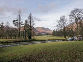 A view of mountains and trees with cars parked along a road at Two Hollens in Ambleside