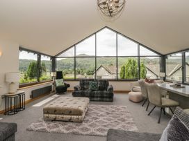 A living room with a sofa and large windows at Two Hollens in Grasmere