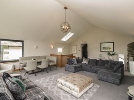A living room with a sofa and dining area at Two Hollens in Grasmere