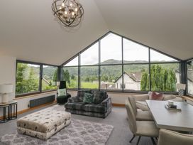 A living room with large windows and seating at Two Hollens in Grasmere