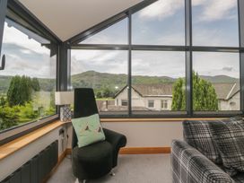 A snug with large windows and a chair at Two Hollens in Grasmere