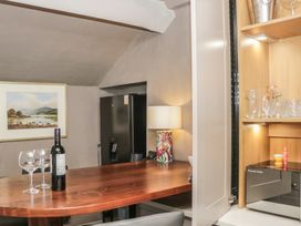 A kitchen with a table and wine on it at Two Hollens in Grasmere