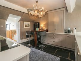 A kitchen with bar stools and cabinets at Two Hollens in Grasmere