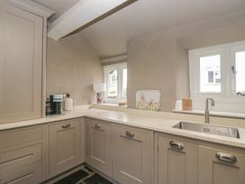 A kitchen with cabinets and sink at Two Hollens in Grasmere