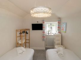 A bedroom with two beds and a television at Two Hollens in Grasmere