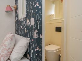 A bathroom with a toilet visible and wallpaper at Two Hollens in Grasmere