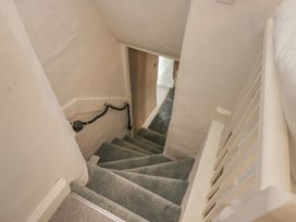 A staircase with carpet and handrail at Two Hollens in Grasmere