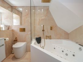A bathroom with bathtub and toilet at Two Hollens in Grasmere