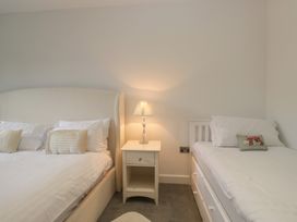 A bedroom with two beds and a nightstand at Two Hollens in Grasmere