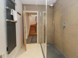 A bathroom with a shower and towel rack at Two Hollens in Grasmere