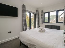 A bedroom with a bed and television at Two Hollens in Grasmere