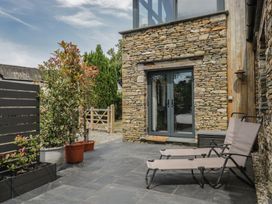 An outdoor space with deck chairs and potted plants at Two Hollens in Grasmere