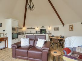 A living room with a sofa and dining area at Yr Awen in Lampeter