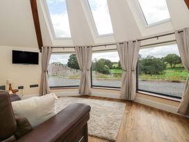 A living room with a sofa and a television at Yr Awen in Lampeter