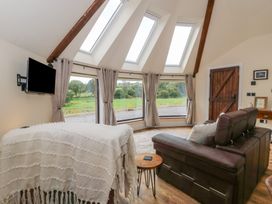 A living room with a sofa and television at Yr Awen in Lampeter