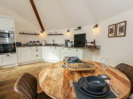 A kitchen with dining area and appliances at Yr Awen in Lampeter