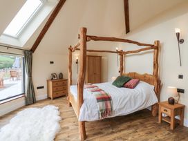 A bedroom with a wooden bed and rustic furniture at Yr Awen in Lampeter
