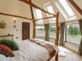 A bedroom with a bed and large windows at Yr Awen in Lampeter